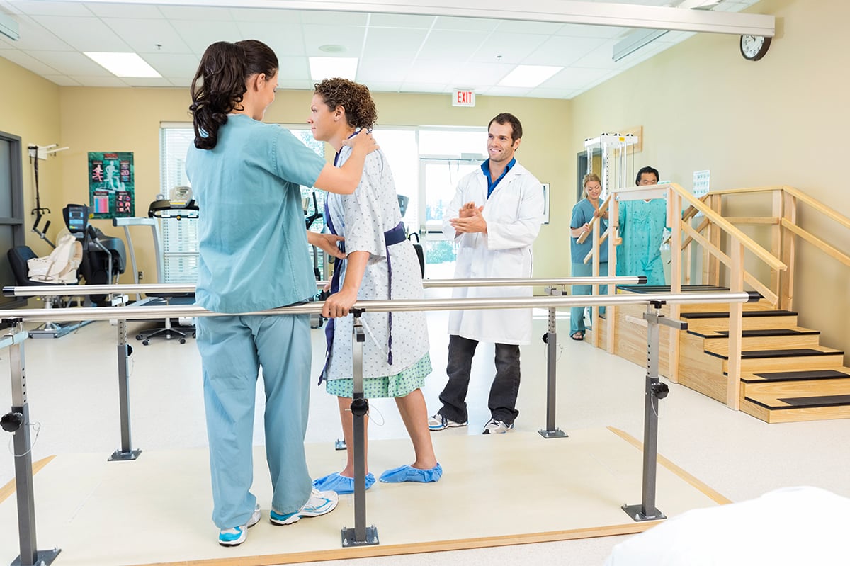 Physical Therapist helping patient to walk