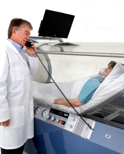 Doctor speaking to patient inside hyperbaric chamber using a connected phone