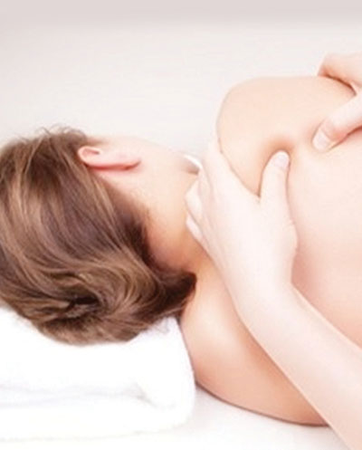 Massage therapist triggering the pressure points on a woman's back
