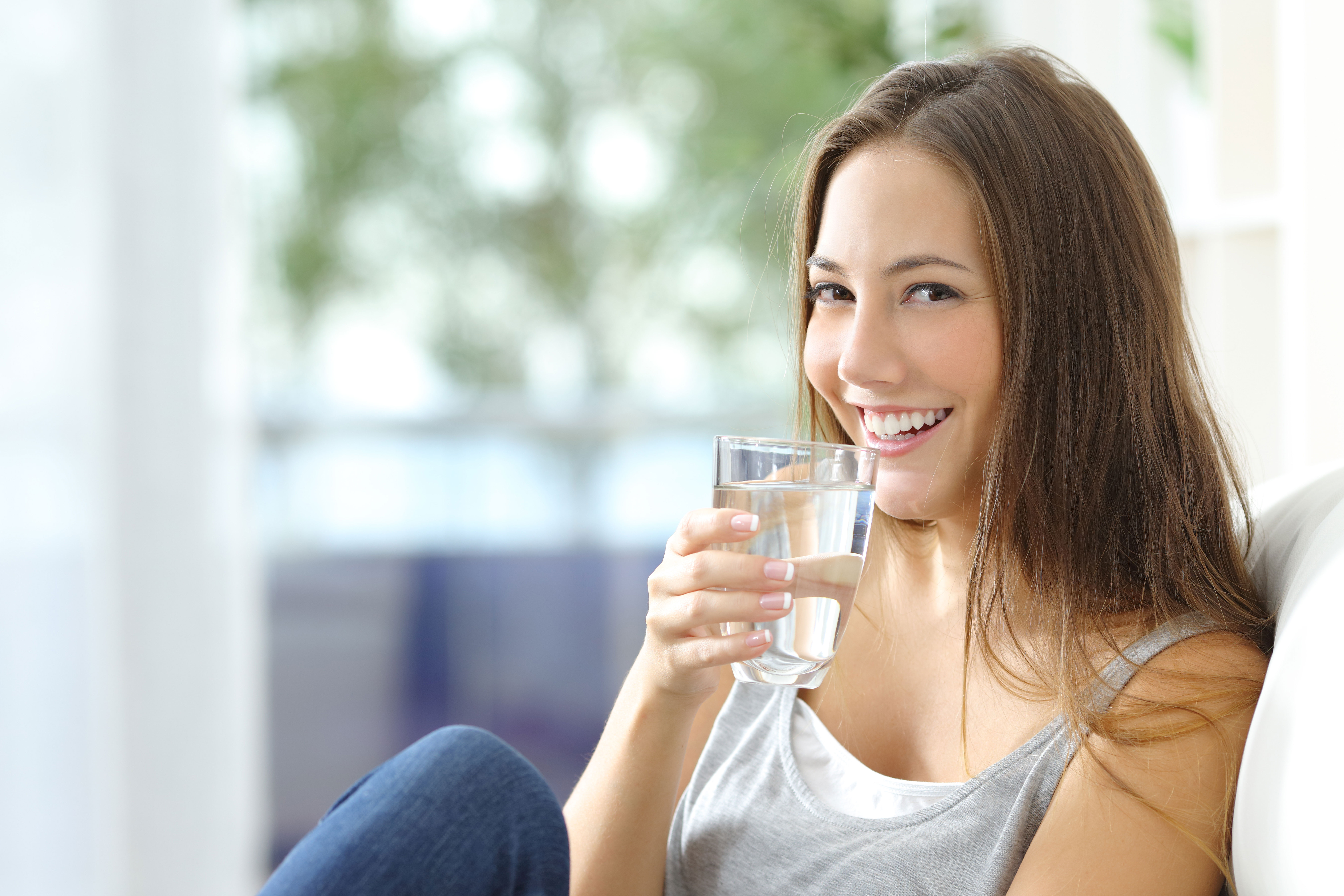 Минеральная вода натощак. Девушка пьет воду. Женщина со стаканом воды. Девушка пьет стакан воды. Девушки и стакан.